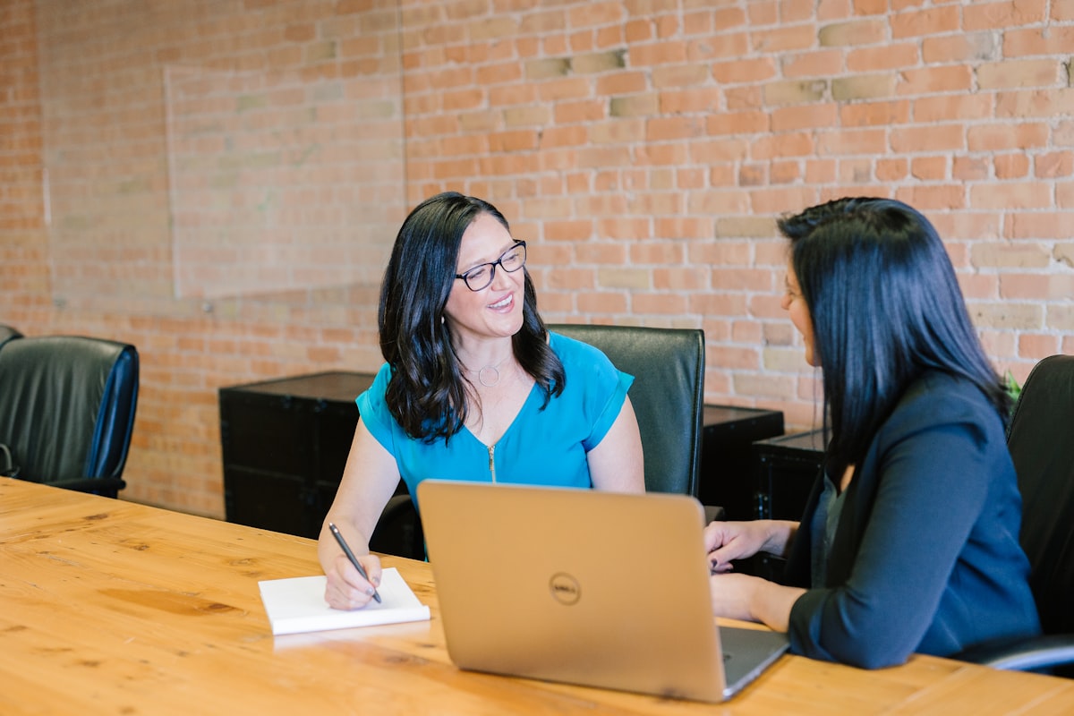 Two professionals discussing organizational planning at a conference table.